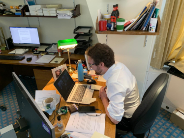 Alexander Stafford MP sits in front of his laptop to join school class on Zoom